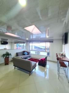 een woonkamer met een bank en een tafel bij Hotel Casa Huesped Kiwi in Bogota