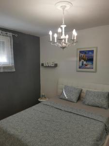 ein Schlafzimmer mit einem Bett und einem Kronleuchter in der Unterkunft Kenzo apartment in Senj