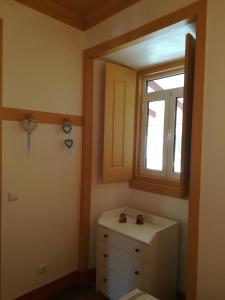 a small room with a window and a dresser at Villa Rominha Alvaiázere - Casa do Canteiro in Alvaiázere