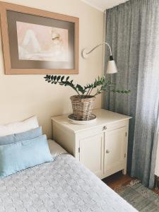 a bedroom with a bed and a potted plant on a cabinet at Linnuse Apartement in Haapsalu