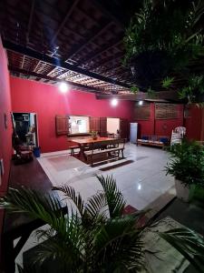 Habitación con mesa de ping pong y paredes rojas. en Casa com Wi-Fi e lazer em Porto de Pedras - AL, en Tatuamunha