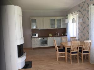 a kitchen with a table and chairs and a fireplace at Allika külalistemaja in Simuna