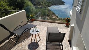 a balcony with two chairs and a table with a view at Alkyon Suites in Áyios Vasílios