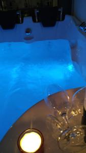 a tub with two wine glasses and a light at Alkyon Suites in Áyios Vasílios