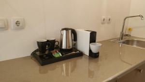 a coffee maker sitting on a counter next to a sink at Alkyon Suites in Áyios Vasílios