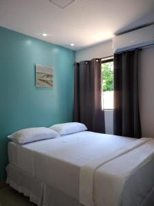 a bedroom with a large bed with a blue wall at Marville Flats in Maragogi