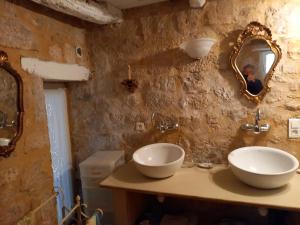 a man taking a picture of a bathroom with two sinks at chambre d hôtes les remparts in Saint-Cyprien