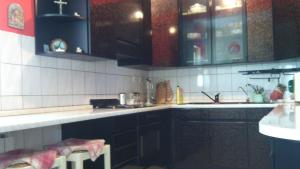 a kitchen with black and white tiled walls and cabinets at Guesthouse Vionica - Peace & Pool in Međugorje