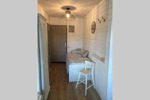 Una pequeña habitación con una cama y una silla dentro. en Magnifique Studio Cassis, en Cassis
