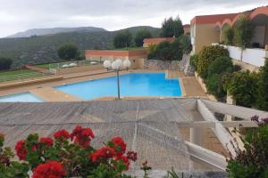un complejo con piscina y flores rojas en Magnifique Studio Cassis, en Cassis