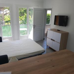 een slaapkamer met een bed en een flatscreen-tv bij Les Lucioles in Cavalaire-sur-Mer