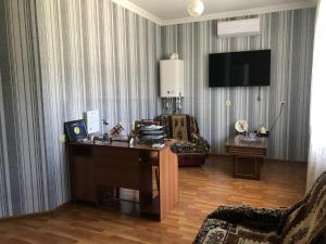 um quarto com uma secretária, um sofá e uma televisão em Hotel Oniks em Kutaisi
