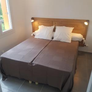 een groot bed met witte kussens in een kamer bij Les Lucioles in Cavalaire-sur-Mer