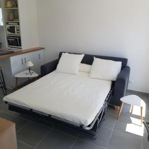een bed met witte lakens en kussens in een kamer bij Les Lucioles in Cavalaire-sur-Mer