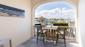 a balcony with a table and chairs and a window at Inn at Camachee Harbor View 14 in St. Augustine