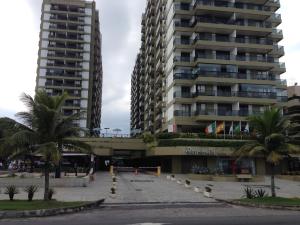 un gran edificio de apartamentos con palmeras enfrente en Barrabella Apart Hotel, en Río de Janeiro