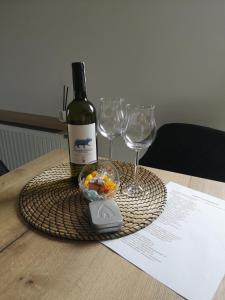 a bottle of wine and two glasses on a table at Apartamenty 48 Letnica in Gdańsk