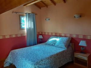Schlafzimmer mit einem Bett mit blauer Decke in der Unterkunft Gîte des Billaudes in Thuret