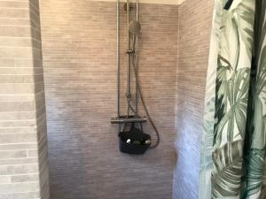 ein Bad mit einer Dusche und einem schwarzen Korb in der Unterkunft Lilla Stubbetorp in Vimmerby