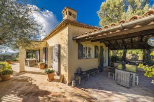 a house with a patio with a bench on it at Villa La Lavande in Valbonne