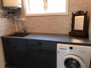 a kitchen with a sink and a washing machine at Lilla Stubbetorp in Vimmerby
