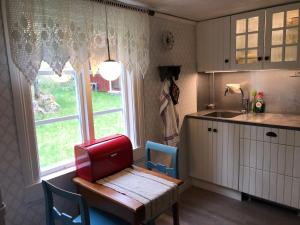 a kitchen with a table and a small table and a window at Lilla Stubbetorp in Vimmerby +11 photos