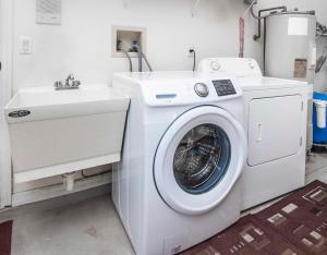 a white washing machine and a sink in a room at SWISS 101 - Lake Olsen in Clermont