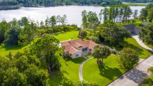 an aerial view of a house on a lawn next to a lake at SWISS 101 - Lake Olsen in Clermont