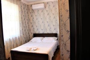 een kleine slaapkamer met een bed met twee handdoeken erop bij Hotel Oniks in Koetaisi