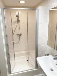 a shower with a glass door next to a sink at Ferienwohnungen Haus Gisela - Unterkunft Schlossberg in Bacharach +17 photos