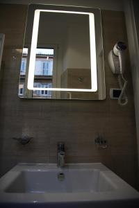 a bathroom with a sink with a mirror and a phone at B&B Federica's House In Rome in Rome
