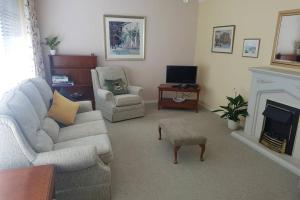 a living room with a couch and a fireplace at The Burrow, a Spacious Bungalow in Heart of NI in Templepatrick