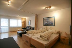 - un salon avec un lit et un canapé dans l'établissement Baron / Baronesse Apartments, à Loèche-les-Bains
