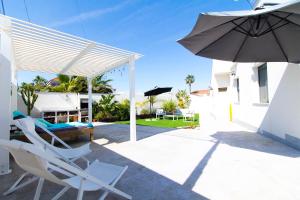 a pair of chairs and an umbrella on a patio at Arenas house in Torrevieja