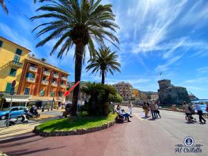 un groupe de personnes se promenant dans une rue bordée de palmiers dans l'établissement AL CASTELLO-VISTA MARE -ROMANTICO e CENTRALE a 20 METRI DAL MARE-toll parking at 15 euro per day to be booked in advance -subject to availability, à Rapallo