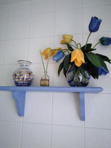Un estante azul con flores y un jarrón. en Manuel Cortina 11, en Villaviciosa