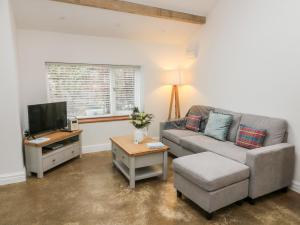 a living room with a couch and a tv at Horncop Nook in Kendal