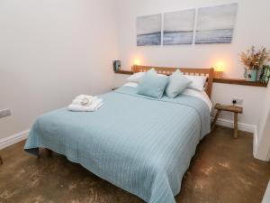 a bedroom with a bed with a blue comforter at Horncop Nook in Kendal
