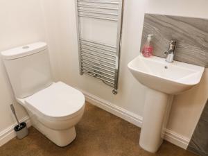 a bathroom with a white toilet and a sink at Horncop Nook in Kendal +7 photos
