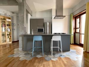 uma cozinha com dois bancos azuis no balcão em Vista Reale Apartment em Caserta