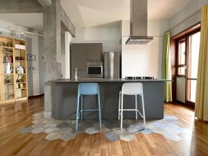 una cucina con due sgabelli blu a un bancone di Vista Reale Apartment a Caserta