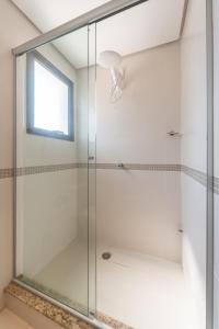 a glass shower in a bathroom with a window at Apartamento Lugar Perfeito Duplex Casemiro 199 in Porto Alegre