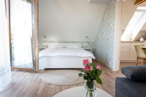 1 dormitorio con 1 cama y un jarrón de flores sobre una mesa en Szigligeti Mandula Kert Vendégház, en Szigliget