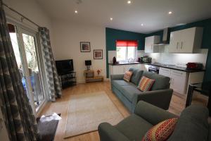 a living room with a couch and a kitchen at The Cabin at Easter Arr in Auldearn