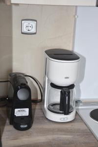 a coffee maker on a counter next to a phone at Marmari MEGALI AMMOS MAISONETTE in Marmarion