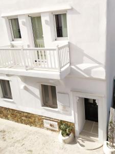 a white building with a staircase and a potted plant at Narcissus Luxury Suites in Naxos Chora