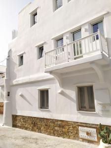 a white building with a balcony on it at Narcissus Luxury Suites in Naxos Chora