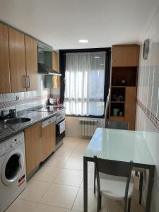 cocina con mesa, fregadero y lavavajillas en Apartamento Paseo de la Losa, en Oviedo
