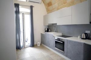 een keuken met een wastafel en een fornuis top oven bij 36 Metri quadri in Polignano a Mare