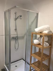 a shower with a glass door and some towels at Casa das Flores in Monte Redondo